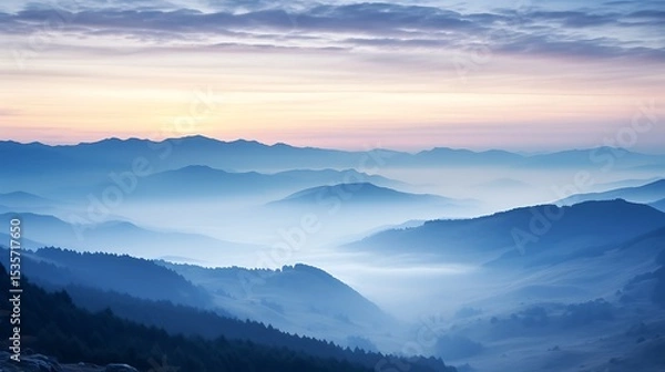 Obraz A subtle sunrise scene of soft blue and pink sky over the Carpathians, layers of mountains fading into the mist, the sun barely peeking above the horizon, creating a peaceful mood.