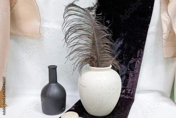 Obraz A black vase and a white vase are on a table