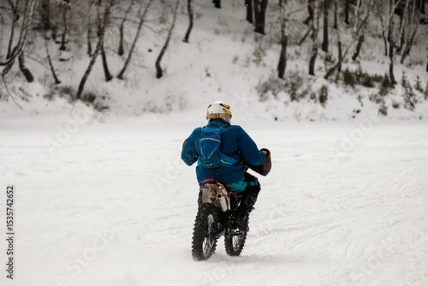 Obraz A man is riding a motorcycle in the snow