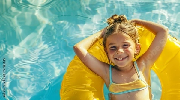 Obraz Young girl with brown hair relaxing in a bright yellow inflatable ring, enjoying a sunny day in a swimming pool, surrounded by shimmering water and playful reflections