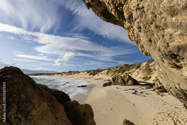 Fototapeta Empty Sandy Ocean Beach with Rocks in the Foreground