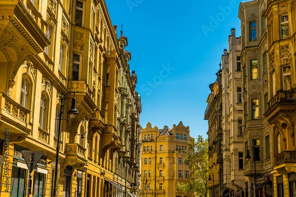 Fototapeta A view along a street of ornate buildings leading from the old town square in central Prague in springtime