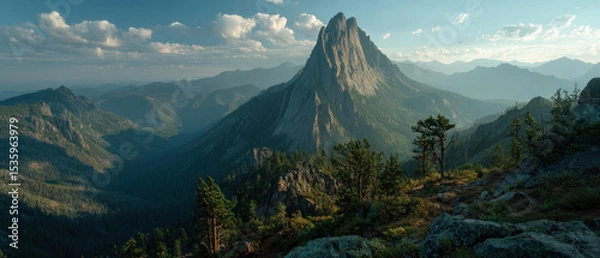 Fototapeta Sustainable path to success is found in natural mountain landscape with rocky peaks and green forest under blue sky with clouds.
