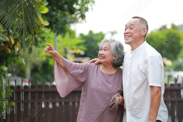 Obraz Asian elderly couple hugging each other living together in retirement. Both are smiling happily looking forward together. Health care in the elderly.