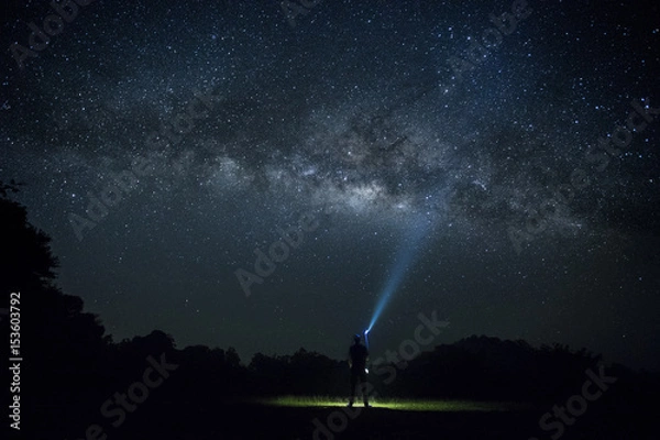 Fototapeta  The Man point flashlight to the milky way galaxy, Night sky with stars, Long exposure photograph, with grain.