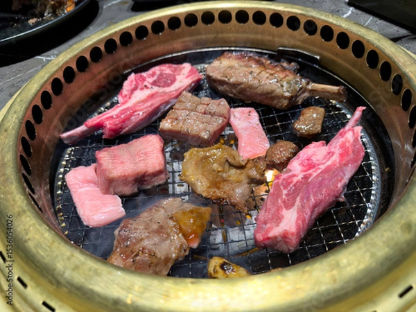 Fototapeta Close up of various raw meat such as beef, pork, and lamb in to a Japan BBQ style gas grill
