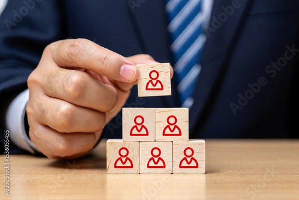 Fototapeta Businessman Building a Team Hierarchy with Wooden Blocks