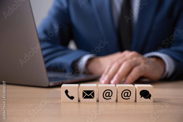Fototapeta Businessman at Laptop with Contact Us Wooden Blocks Showing Email Phone and Chat