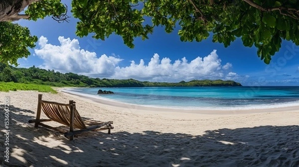 Fototapeta A serene beach scene with a wooden beach chair under the shade of trees on a sunny day