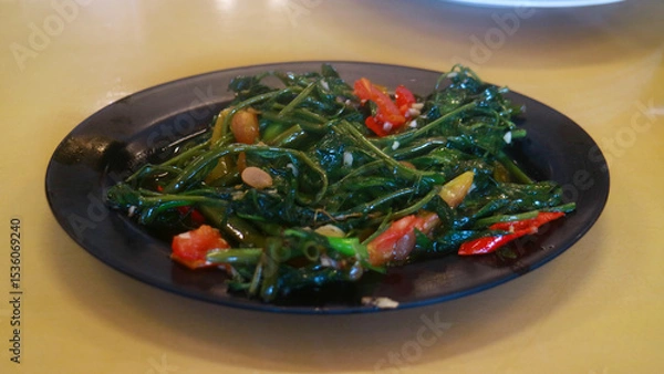 Obraz Stir-fried water spinach on a plate. Ready to eat.