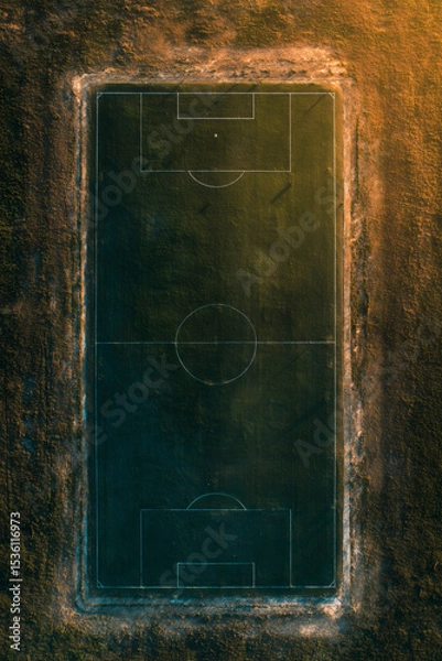 Fototapeta Aerial view of a soccer field surrounded by brown grass, showcasing sports and recreational space.