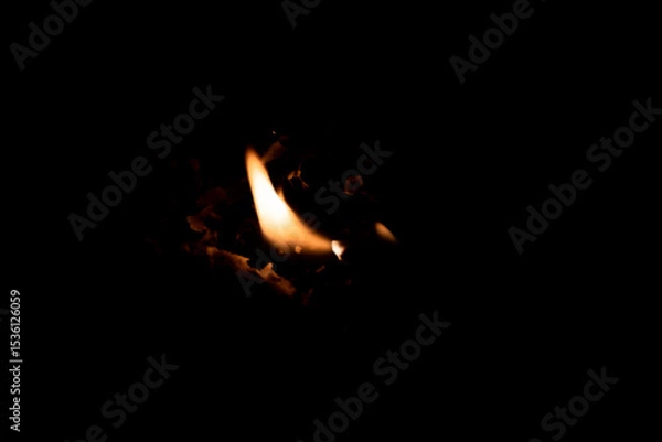 Fototapeta Close-up image of bright orange flames against a backdrop of black ash and burnt debris. A strong visual composition depicting the power, energy, and beauty of nature in the form of the fire element. 