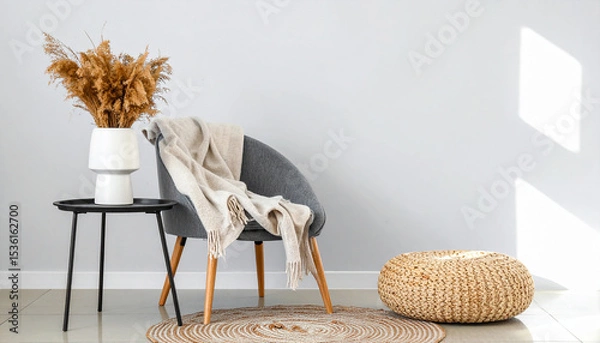Fototapeta Cozy corner arrangement: This image showcases a serene and inviting interior setting, with a stylish chair, a small table, and decorative elements like a textured pouf, a round rug.