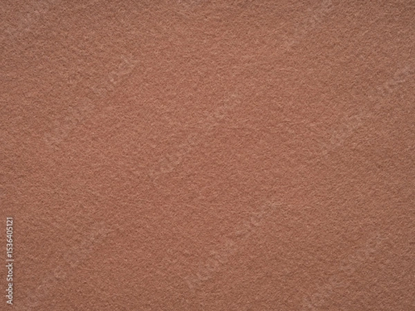 Fototapeta An inviting landscape of terracotta felt, the surface exudes the warmth of earthenware in the soft afternoon glow