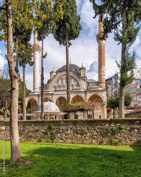 Fototapeta Muradiye Mosque in Manisa, Turkey. Historic Ottoman architecture with minarets, dome, and arches, surrounded by trees and a garden
