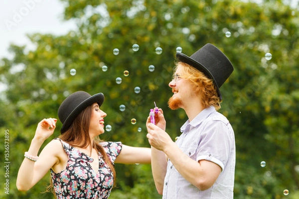 Fototapeta Couple blowing soap bubbles, having fun