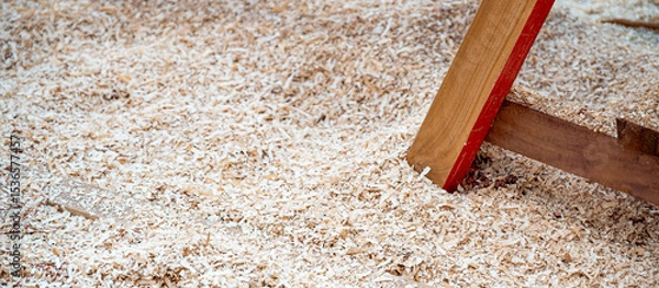Fototapeta Sawdust heap under workbench leg in the wood workshop. Wooden dust from planing and sawing timber. Wood production waste. lumber industry concept