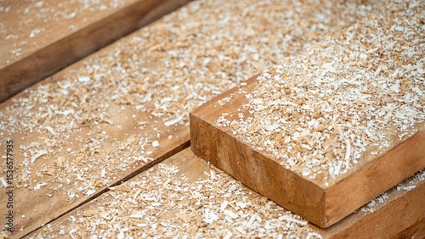 Fototapeta Sawdust spreading on timber stack in the wood workshop. Wooden dust from planing and sawing timber. Wood production waste. lumber industry concept