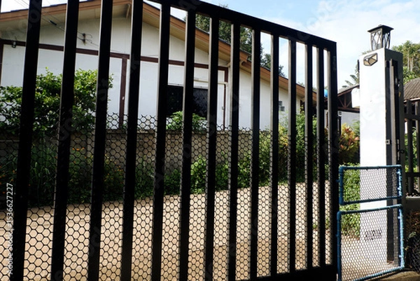 Fototapeta Iron gate in front of the house and small PVC gate to keep out dogs