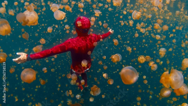 Obraz Freediver swims underwater in the lake full of jellyfish. West Papua, Misool, Indonesia