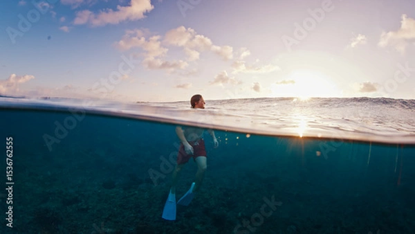 Obraz Man swims in the sea with breaking waves. Splitted shot of the male swimming in the ocean on a surfing spot