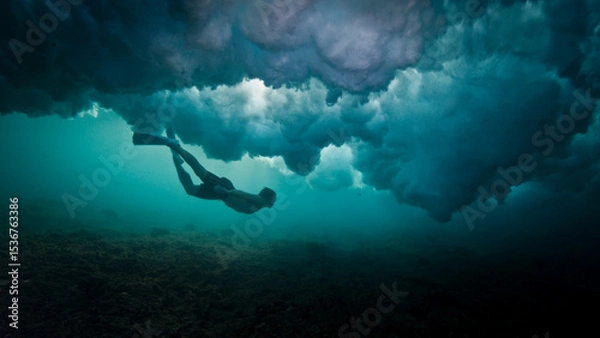 Obraz Man dives and swims underwater under the breaking wave