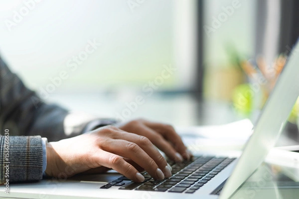 Fototapeta Close up of business woman hands typing on laptop computer, searching and surfing the internet on office desk