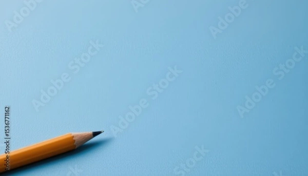 Fototapeta Graphite Pencil Lying on a Light Blue Background in a Simplistic Artistic Workspace Setting