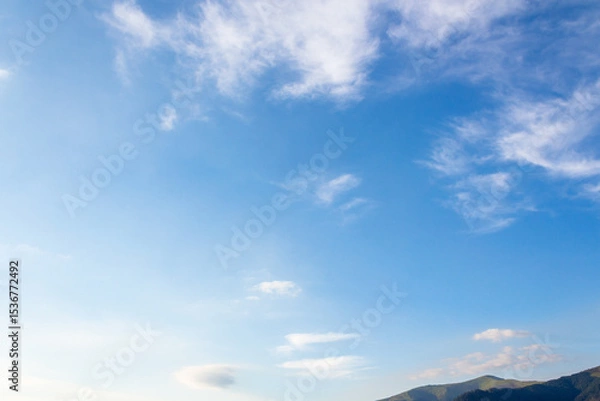 Fototapeta nature backdrop with blue sky and white fluffy clouds in morning light. bright and sunny weather forecast background