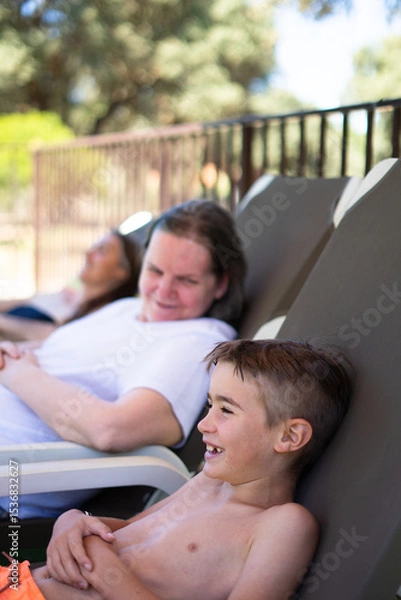 Fototapeta Family relaxing and enjoying summer vacation by the pool