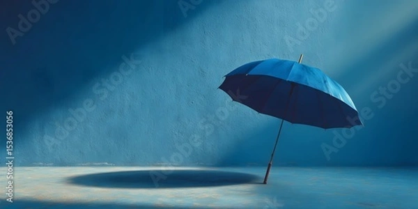 Fototapeta Minimalist product shot of a single elegant dark blue umbrella, open and upright. It is set against a textured light blue background with soft lighting.
