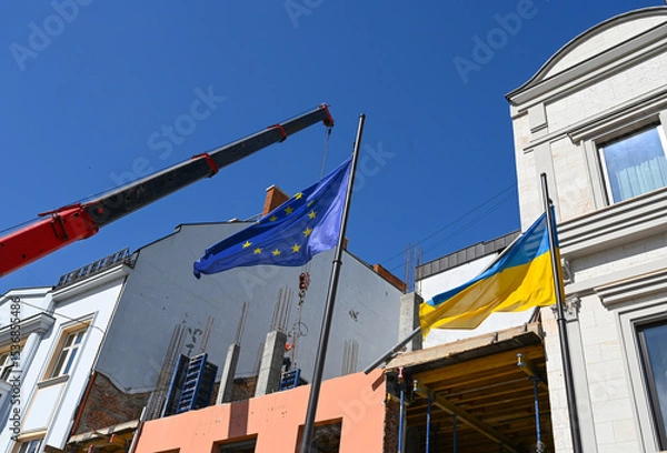 Fototapeta New flags raised to symbolize unity in a construction area under clear blue sky