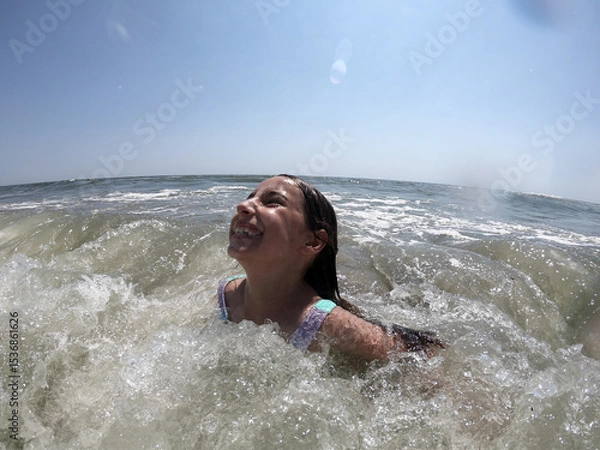 Obraz Powerful ocean waves splashing on child girl in summer vacation