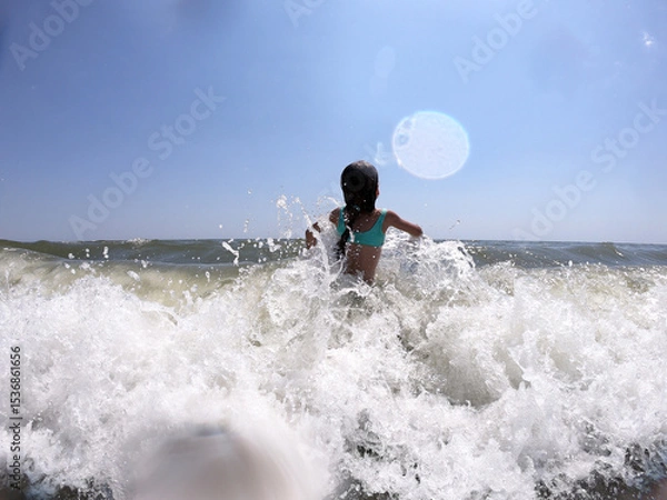 Obraz Powerful ocean waves splashing on child girl in summer vacation