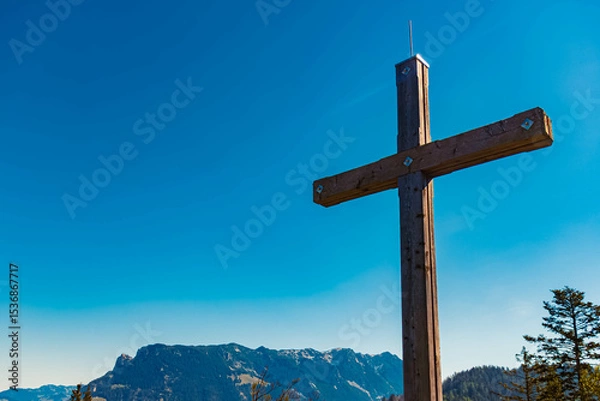 Obraz Alpine spring view with a summit cross and Mount Zahmer Kaiser in the background at Kaiserlift Kufstein, Tyrol, Austria