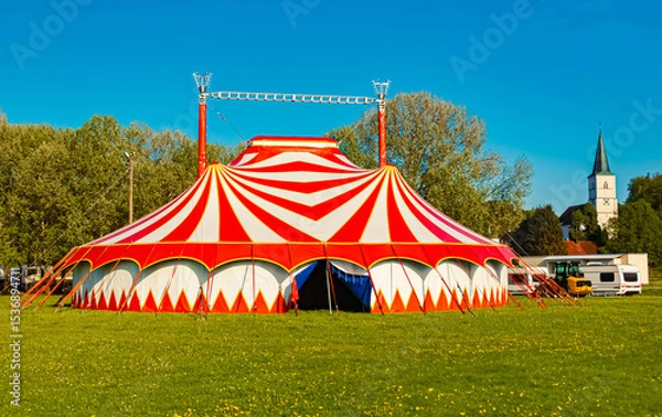 Obraz Spring landscape with a red and white circus tent and a church on a sunny day at Postmuenster, Rottal Inn, Bavaria, Germany