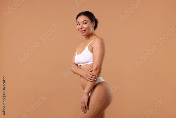 Obraz Woman in white underwear with smooth skin after epilation procedure on beige background