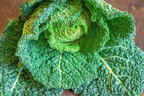 Fototapeta Savoy cabbage head. Cabbage with crinkled, bright green leaves  on rustic table