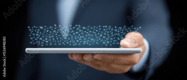 Fototapeta Person in suit holds tablet with digital icons floating above it, symbolizing technology and communication