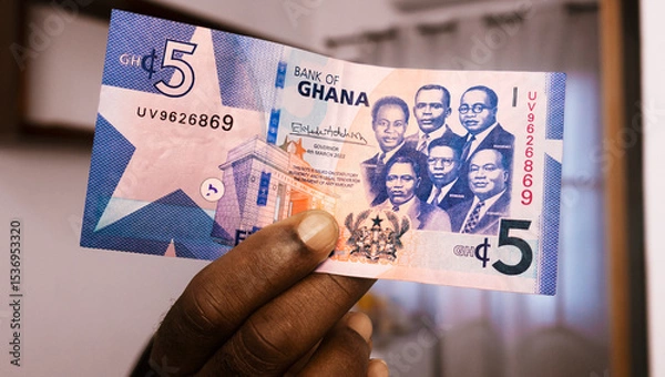 Obraz closeup of Black person hands inspecting and checking pointing raising 5 Ghanaian cedi note. watermark on money. Verification of paper currency not fake counterfeit original real