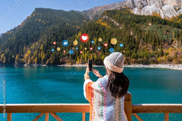 Fototapeta Young female tourist enjoying and taking a photo at beautiful autumn scenery landscape at jiuzhaigou national park in Sichuan, China