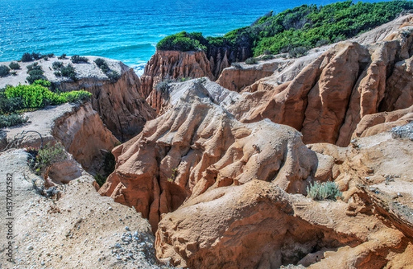 Fototapeta beautiful beach in the Atlantic Ocean bordered by hard sand cliffs forming a canyon Medides beach in Portugal