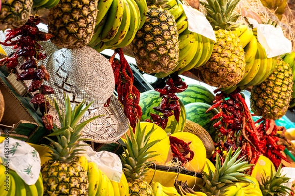 Fototapeta Colorful market life with exotic fruits and regional products and straw hat