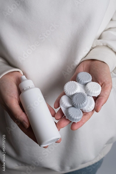 Fototapeta Contact lenses, case and bottle with solution and eye drops on white background. Eye health and care, vision, ophthalmology concept, close-up 