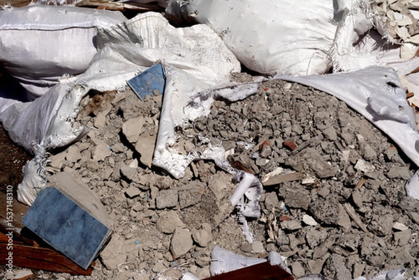 Fototapeta Construction debris in open sacks – illegal disposal of building materials in urban space