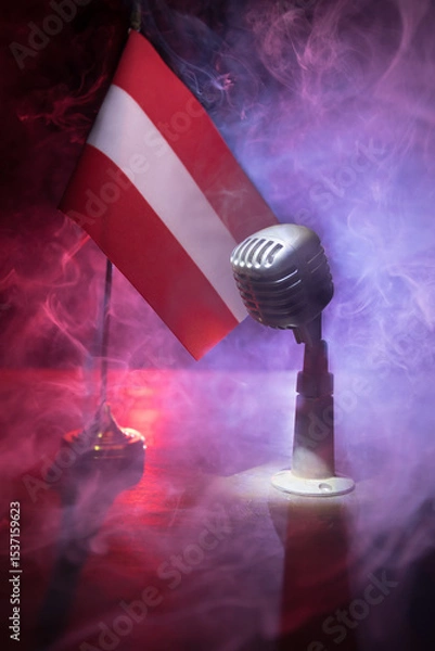 Fototapeta Microphone on a background of a blurry flag of Austria close-up. dark table decoration
