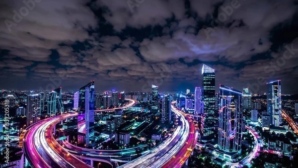 Fototapeta Light trails illuminate the busy highways weaving through the vibrant cityscape of jakarta, indonesia, at night, creating a mesmerizing display of urban energy and dynamism under a cloudy sky