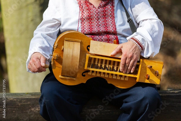 Obraz The wheel lyre or relya is an ancient stringed bowed musical instrument in which the role of the bow is performed by a wheel. Structurally similar to the hurdy-gurdy.