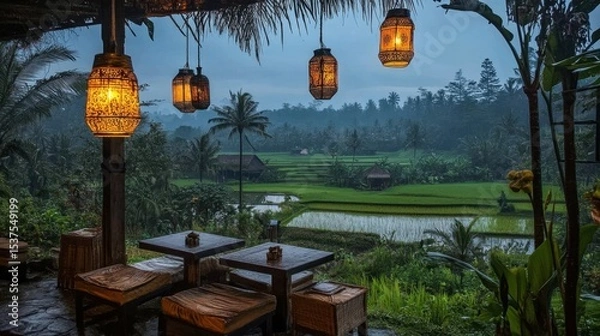 Fototapeta Open-air seating at tourist accommodation with view of rice paddies and hanging lanterns