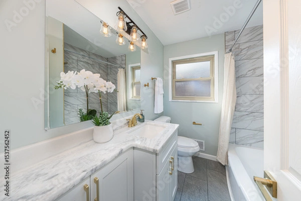 Fototapeta bathroom has been updated with a new vanity new tile and new fixtures installed by a professional